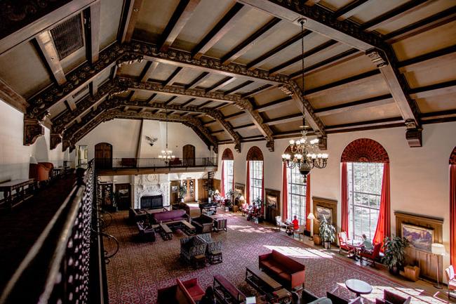 expansive room with couches, large run, and wooden paneling for the ceiling